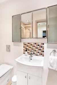 a white bathroom with a sink and a mirror at Granville Apartments Harrogate in Harrogate