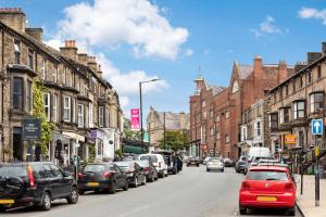 a busy city street with cars parked on the street at Granville Apartments in Harrogate