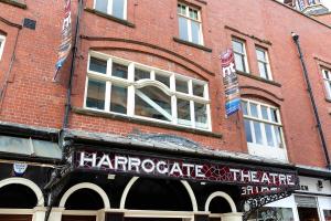 a red brick building with a harrootics theatre sign on it at Granville Apartments in Harrogate +1 photo