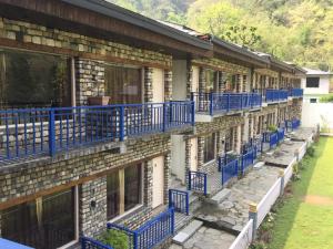 a row of houses with blue balconies on them at Pacific Inn Resort Rishikesh in Rishīkesh