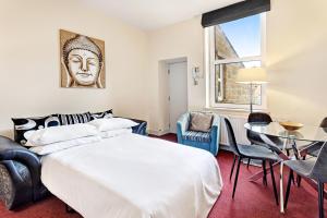 een slaapkamer met een bed en een tafel en stoelen bij Granville Apartments Harrogate in Harrogate