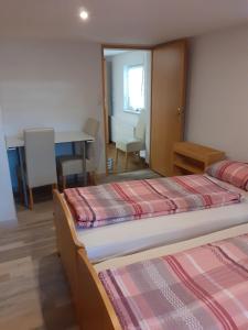- 2 lits dans une chambre avec une table et une salle à manger dans l'établissement Ferienwohnung Dilara, à Immenstadt