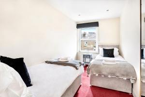 two beds in a room with a red carpet at Granville Apartments Harrogate in Harrogate