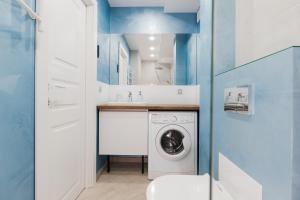 a bathroom with a washing machine and a sink at CityApartments Kyiv Palace "Ukraine" in Kyiv