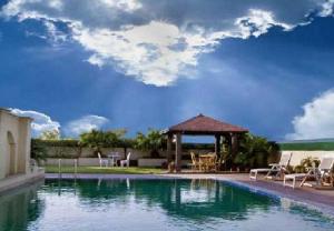 uma piscina com um gazebo e um gazebo em Savoy Suites Noida em Noida