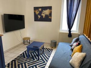 sala de estar con sofá azul y TV en Appartement avec place de parking en Yzeure