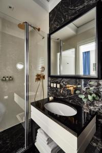 a bathroom with a shower, sink, and tub at Teatro Hotel in Warsaw