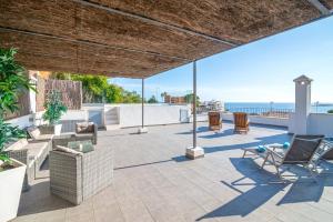 a patio with chairs and a view of the ocean at Villa Harmonía en Palma piscina/mar/playa in Palma de Mallorca