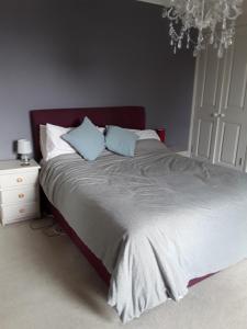 a bedroom with a large bed with blue pillows at Town House Bridport Dorset in Bridport