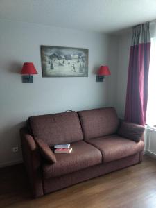 uma sala de estar com um sofá castanho e 2 candeeiros em VVF Val-Cenis Haute-Maurienne em Lanslevillard