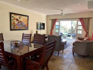 a living room with a dining room table and chairs at Barbados 13, Caribbean Estate - PRIVATE POOL!! in Port Edward