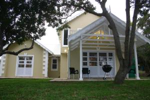 una casa con dos sillas delante en Barbados 13, Caribbean Estate - PRIVATE POOL!! en Port Edward