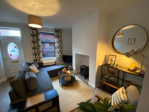 a living room with a couch and a mirror at Pillow Properties - Barnsley Centre in Barnsley