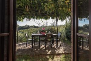 a table with chairs and a view out a window at Agriturismo Rigone in Chianti in Montaione