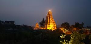 a lit up building with a light on top at night at Padmaa Hampi Villa in Hampi