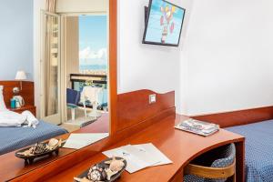 a hotel room with a desk and a mirror at Hotel Palace in Bibione