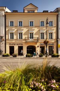 a large building with people sitting in front of it at Hotel Teatro Boutique Old Town in Warsaw