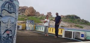 a man and a woman standing next to a mural at Padmaa Hampi Villa in Hampi