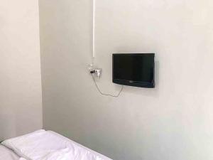 telewizor z płaskim ekranem wiszący na białej ścianie w obiekcie Griya Fadamas Syariah near Taman Hijau Demangan Madiun Mitra RedDoorz w mieście Madiun