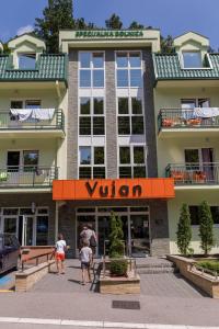 a view of a hotel with people walking in front of it at Clinic for Rehabilitation Vujan in Čačak