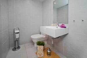 a white bathroom with a sink and a toilet at Victoria Diagonal Mar Barcelona in Barcelona