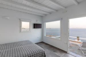 1 dormitorio con cama y vistas al océano en Sea Wind Apartments, en Agios Stefanos