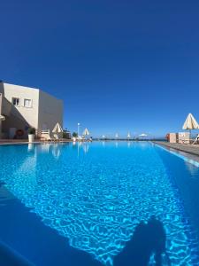 a person standing in the water in a swimming pool at Nautica Hotel Apartments in Stavromenos