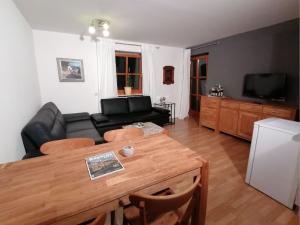 a living room with a black couch and a table at Komfort Feriendomizil JAKOBI in Dietfurt