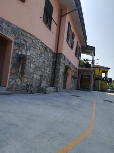 un edificio con una pared de piedra junto a un aparcamiento en La Fontanella Apartment, en Polverara