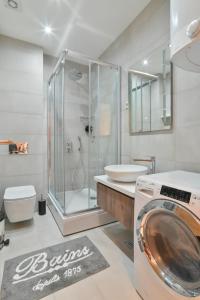 a bathroom with a shower and a washing machine at Apartman Ivona - Vila Peković in Zlatibor