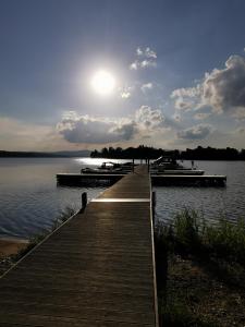 a dock with boats on a lake with the sun in the sky at Lipno-Lake in Frymburk