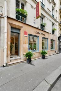 a store front of a building with potted plants at Louisa Hotel Paris in Paris