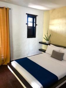 ein großes Bett in einem Zimmer mit Fenster in der Unterkunft Vibe House Arraial in Arraial do Cabo