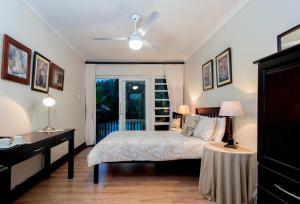 a bedroom with a bed and a ceiling fan at The Brother's Guest House in Durban