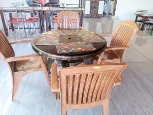 a wooden table with four chairs and a table with a glass top at Maavaa Dreamland in Lansdowne