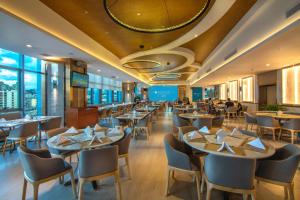 a restaurant with tables and chairs and windows at Pullman Guiyang in Guiyang