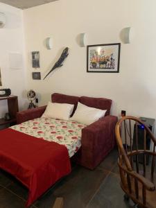 a bedroom with a red bed and a couch at Casa Canoa - climatizada e com piscina in Piranhas