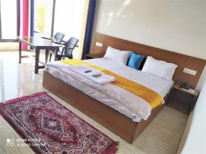 1 dormitorio con 1 cama grande con mesa y alfombra en Maavaa Dreamland en Lansdowne