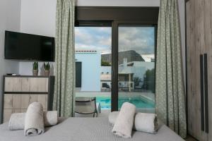 a bedroom with a bed and a view of a pool at Villa Stavelia in Gouves