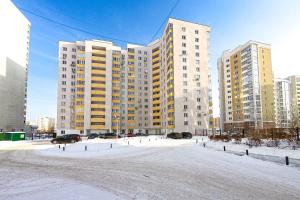 エカテリンブルクにあるEtazhiDaily Soyuznayaの高層ビルの前の雪屋根付き駐車場