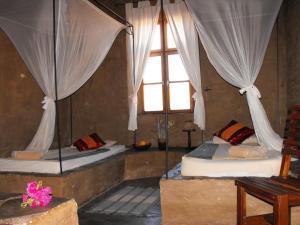 two beds in a room with a window at Fort Sesfontein Lodge & Safaris in Sesfontein