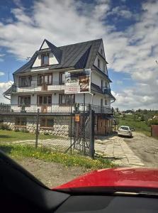 una grande casa bianca con il tetto nero di "U Skowronków" a Bukowina Tatrzańska