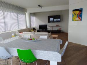 uma sala de estar com uma mesa e cadeiras verdes em Scheldepunt em Gante