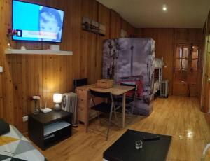 a living room with a table and a tv on a wall at GRAN ESTUDiO MARIBEL in Sierra Nevada