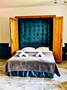 sypialnia z dużym łóżkiem z niebieskim zagłówkiem w obiekcie Dwór Karwacz w mieście Przasnysz