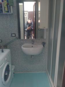 Ein Mann fotografiert ein Waschbecken im Badezimmer. in der Unterkunft Villa Cesarea in Porto Cesareo