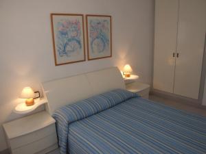 una piccola camera con un letto e due lampade di Somni Cambrils a Cambrils