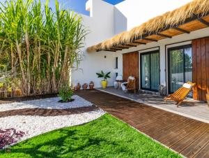 a house with a thatched roof and a patio at Home Beach Dream House in Carvalhal