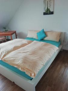 een bed in een kamer met een blauw en wit matras bij Hotel Zur Mosel in Minheim