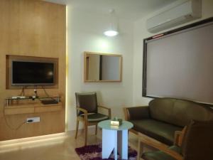 a living room with a couch and a tv and a table at Meritas Seawind Beach Resort, Shrivardhan in Srīvardhan